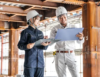 詳細の調整のイメージ写真。作業員2人が図面を見ながら話し合っている。